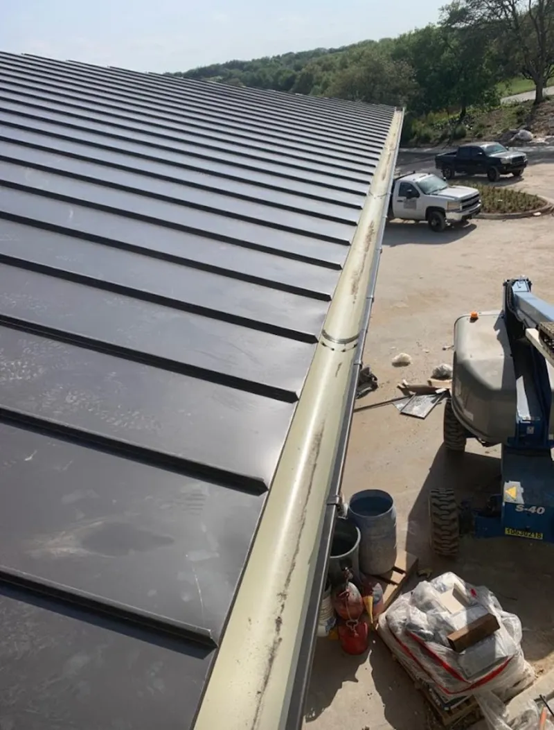 Standing seam panel and gutter detail on a metal roofing jobsite in Yankton